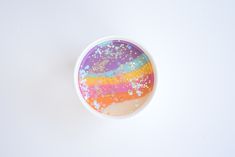 a white bowl filled with colorful liquid and sprinkles on top of a table