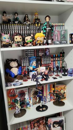 a book shelf filled with anime figurines and other collectibles on top of it