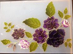 some purple flowers and green leaves on a white surface with brown trimmings in the center