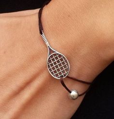 a tennis racquet bracelet on a woman's wrist