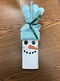 an origami snowman with a blue hat and scarf wrapped around it's head