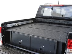 the back end of a pickup truck with its bed open and two drawers on it