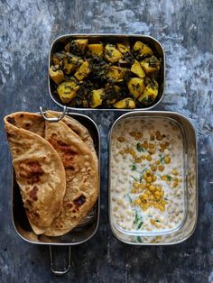 three metal trays filled with food on top of a table