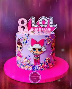 a birthday cake decorated with the theme of lol surprise is displayed on a table