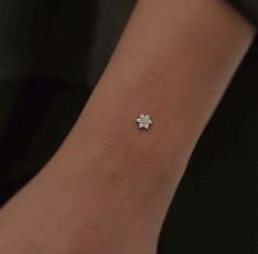 a woman's arm with a small white flower on it