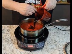 a person pouring sauce into a pot on top of a stove