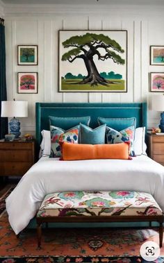 a bedroom with white walls, blue bedding and pictures on the wall above it