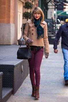 the woman is walking down the sidewalk with her handbag