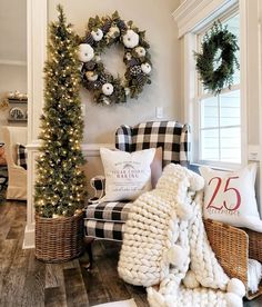 a living room decorated for christmas with wreaths on the wall and plaid chair in front