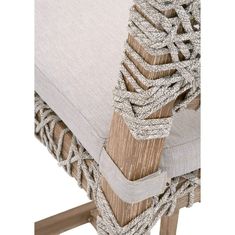 an upholstered chair with rope wrapped around the back and seat cushions on it