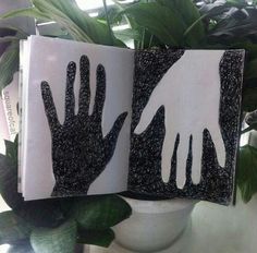 two handprints are placed next to each other in front of a potted plant