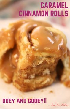 a close up of two cinnamon rolls on a plate with the words caramel cinnamon rolls