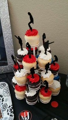 a table topped with cupcakes covered in red, white and black frosting