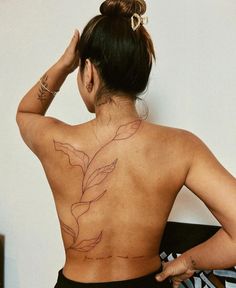 the back of a woman's body with tattoos on her upper and lower back