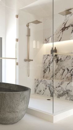 a bathtub sitting in the middle of a bathroom next to a walk in shower