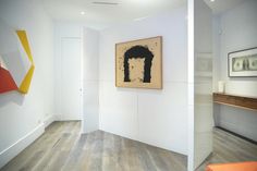 two paintings hang on the wall next to each other in an empty room with wood floors