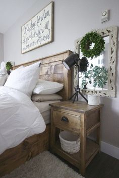 a bed with white sheets and pillows next to a wooden night stand in a bedroom