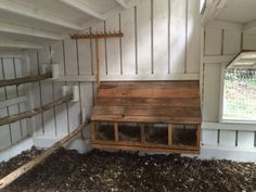 a wooden bench sitting in the corner of a room next to a window and hay