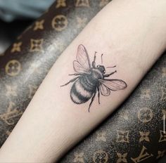 a black and white bee tattoo on the right arm, it looks like he is flying