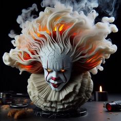 a creepy mask with red eyes and white hair on top of a table next to a lit candle