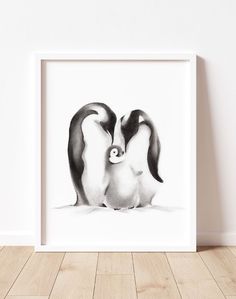 a black and white photo of two penguins with one penguin holding the other's head