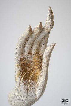 a white and gold hand sculpture on top of a table