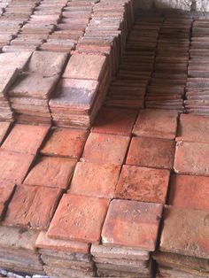 red bricks stacked on top of each other in an area that is covered with cement