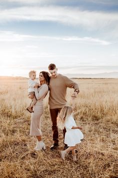 a man, woman and child walking through a field