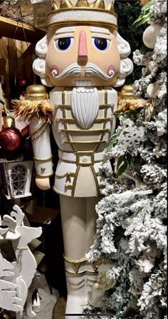 a statue of a nutcracker in front of a christmas tree