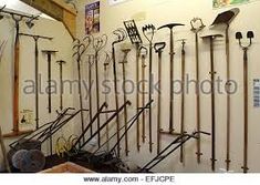 a room filled with lots of different types of shovels and poles on the wall