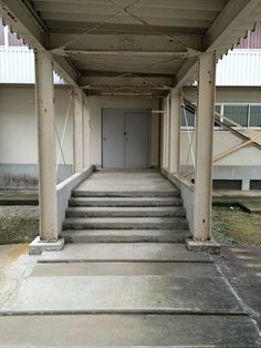 an empty building with some steps leading up to the door and another set of stairs