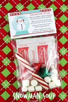 some candy canes and marshmallows in a bag on a red and green tablecloth