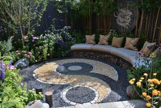 a garden with rocks, gravel and flowers