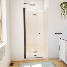 a bathroom with a shower, toilet and sink in it's corner area next to a window