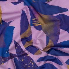 a purple and blue fabric with gold paint splattered on it