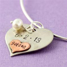 a heart charm with the word gotno written on it and a pearl bead