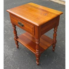 a small wooden table with two drawers on one side and an open drawer on the other