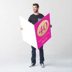 a man holding a pink and white sign with the number five on it's side