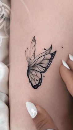 a woman's stomach with a butterfly tattoo on her belly and the bottom part of her leg