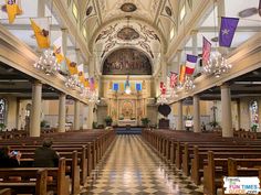 the interior of a large church with pews and flags hanging from the ceiling above