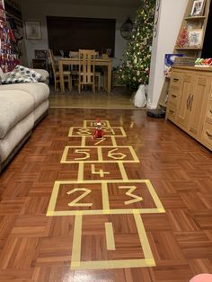 a wooden floor with numbers painted on it in a living room next to a christmas tree