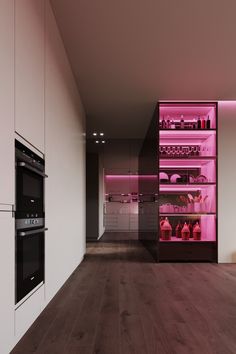 an empty kitchen with pink lighting on the shelves