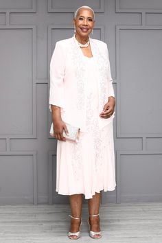 an older woman in a white dress and jacket posing for the camera with her hand on her hip