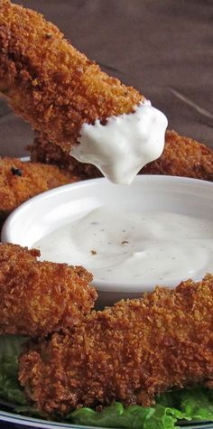 fried chicken is being dipped with ranch dressing