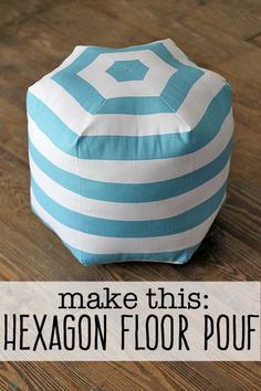 a blue and white striped poufce sitting on top of a wooden floor next to a wall