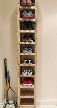 a wooden rack with shoes and tennis rackets on it in the corner of a room