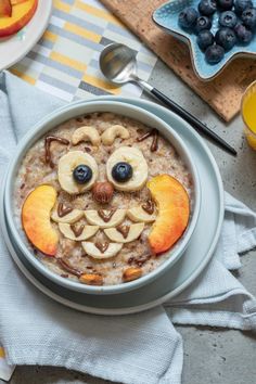 bowl of oatmeal with fruit and an owl face