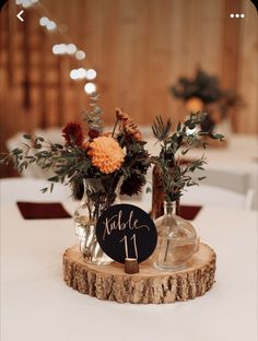 there are two vases with flowers in them on top of a wooden stand that says table 11