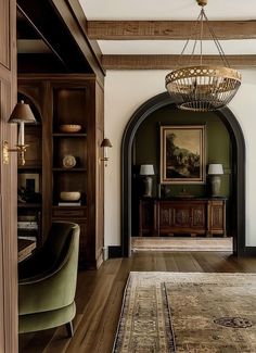 a living room filled with furniture and a chandelier hanging from the ceiling next to a doorway