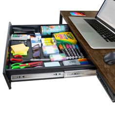 a laptop computer sitting on top of a desk next to a drawer filled with office supplies